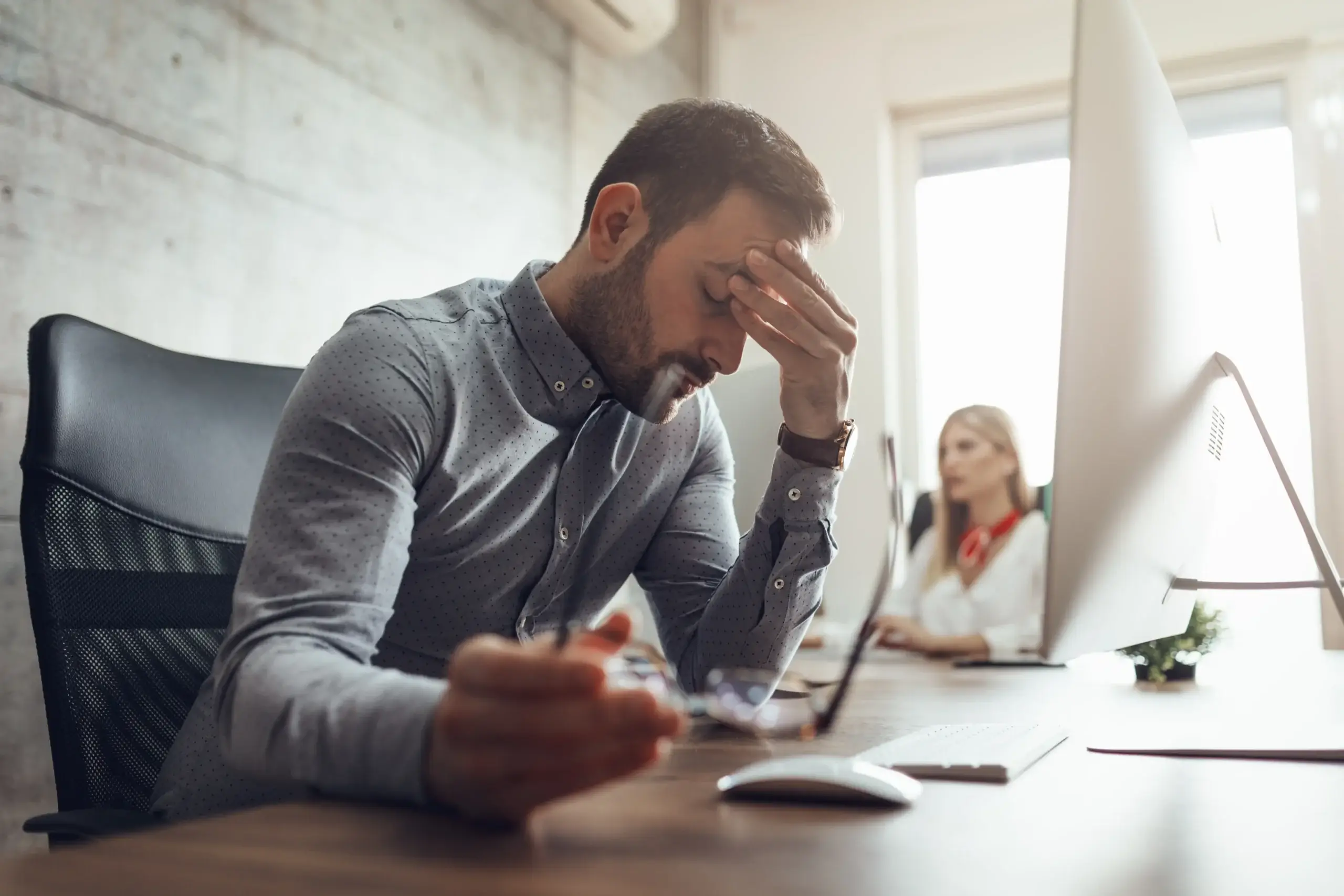 Mann mit Burnout Syptomen mentale Gesundheit am Arbeitsplatz