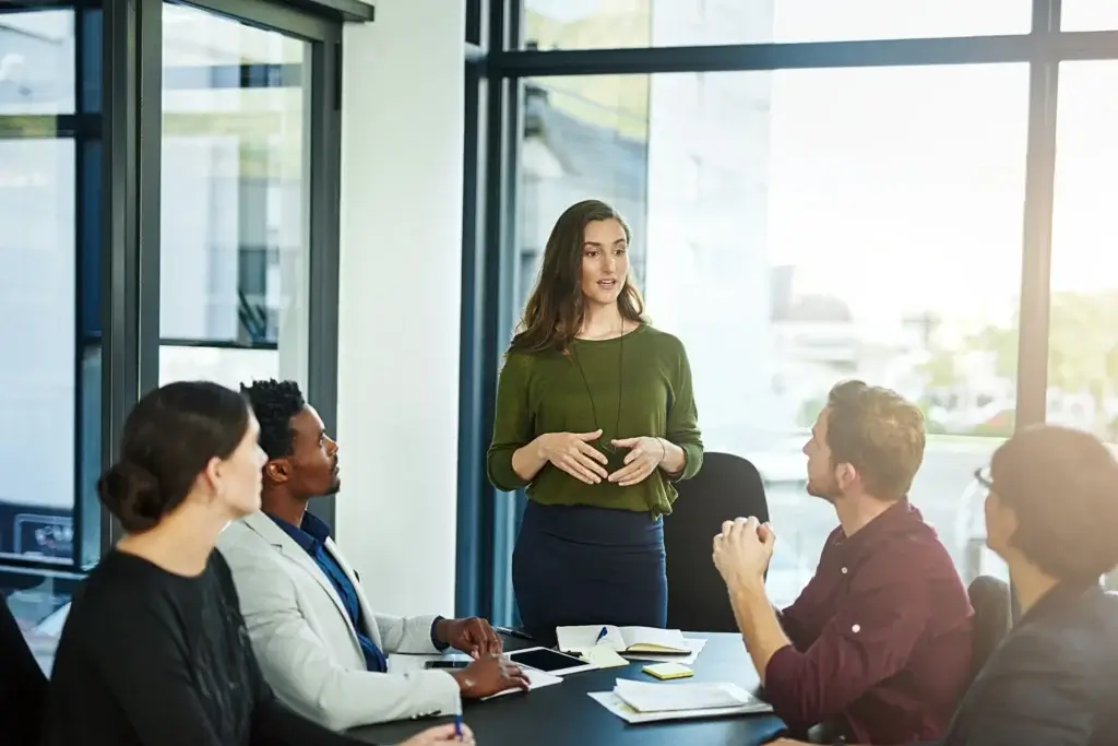 Mindful Leadership in Aktion: Junge Führungskraft steht vor Ihrem Team